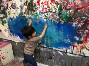小学生 絵画教室 壁に絵の具を塗る子ども